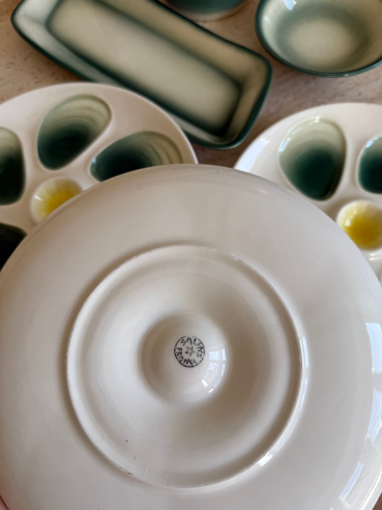 Close-up of a ceramic dish with a visible brand logo french oyster plate