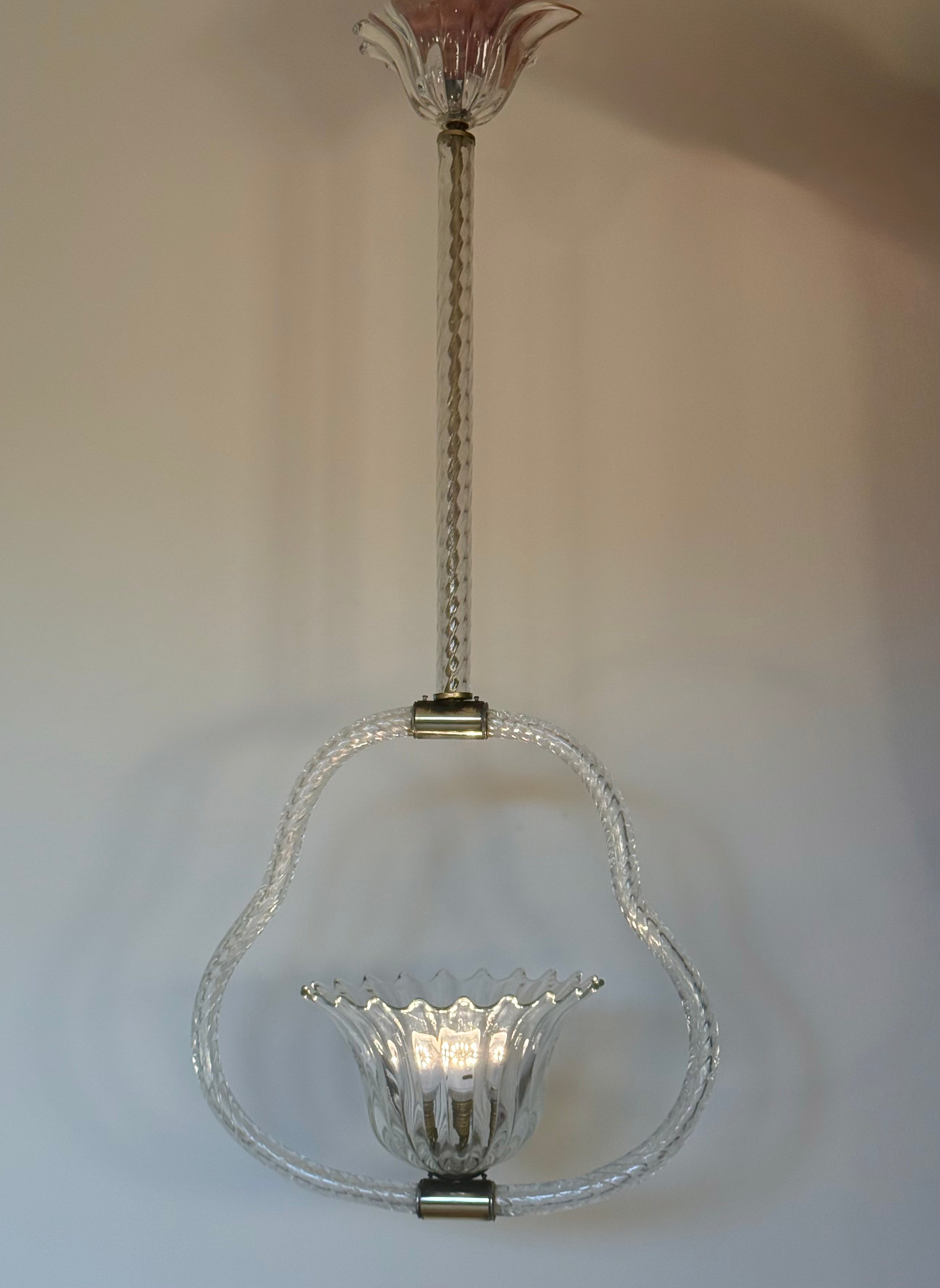 A vintage-style clear glass chandelier with a sculptural looped frame, a fluted glass bowl shade, and a twisted metal stem, shown against a plain light background.