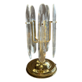 A vintage-style brass and clear glass candelabra with multiple vertical clear glass shades and a round polished brass base, shown against a plain white background.