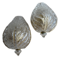 Two decorative glass ornaments with textured surface on a white background