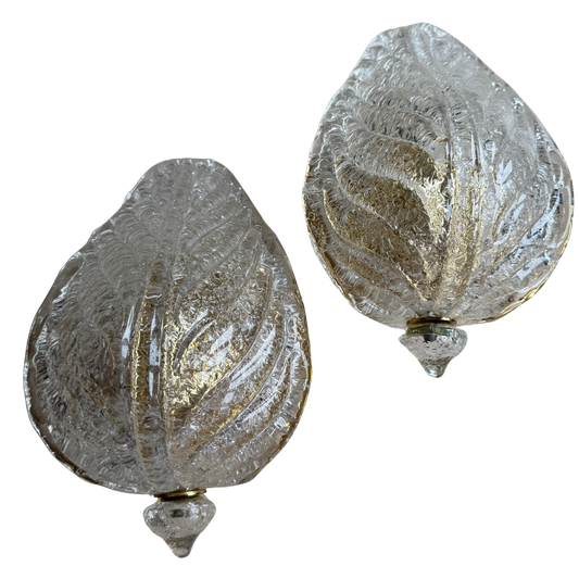 Two decorative glass ornaments with textured surface on a white background