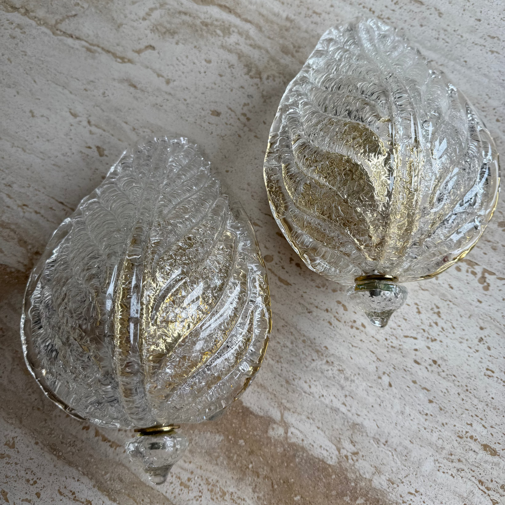 Two decorative glass ornaments on a textured surface