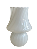 A white glass table lamp with a flared, scalloped shade and a rounded base, shown on a plain white background.