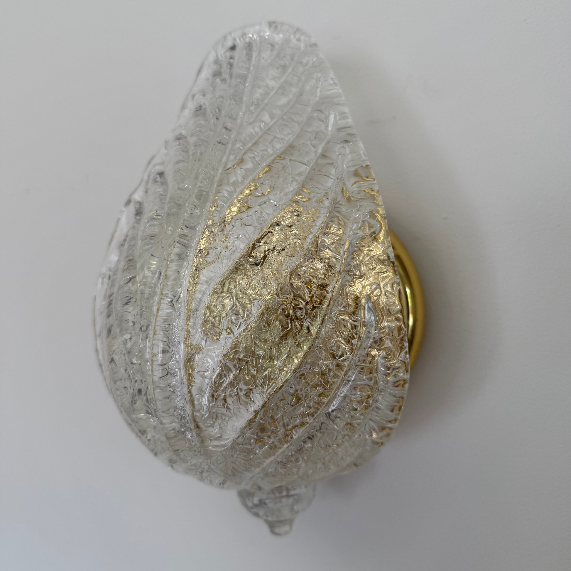 Decorative wall sconce with gold and silver design on a white background