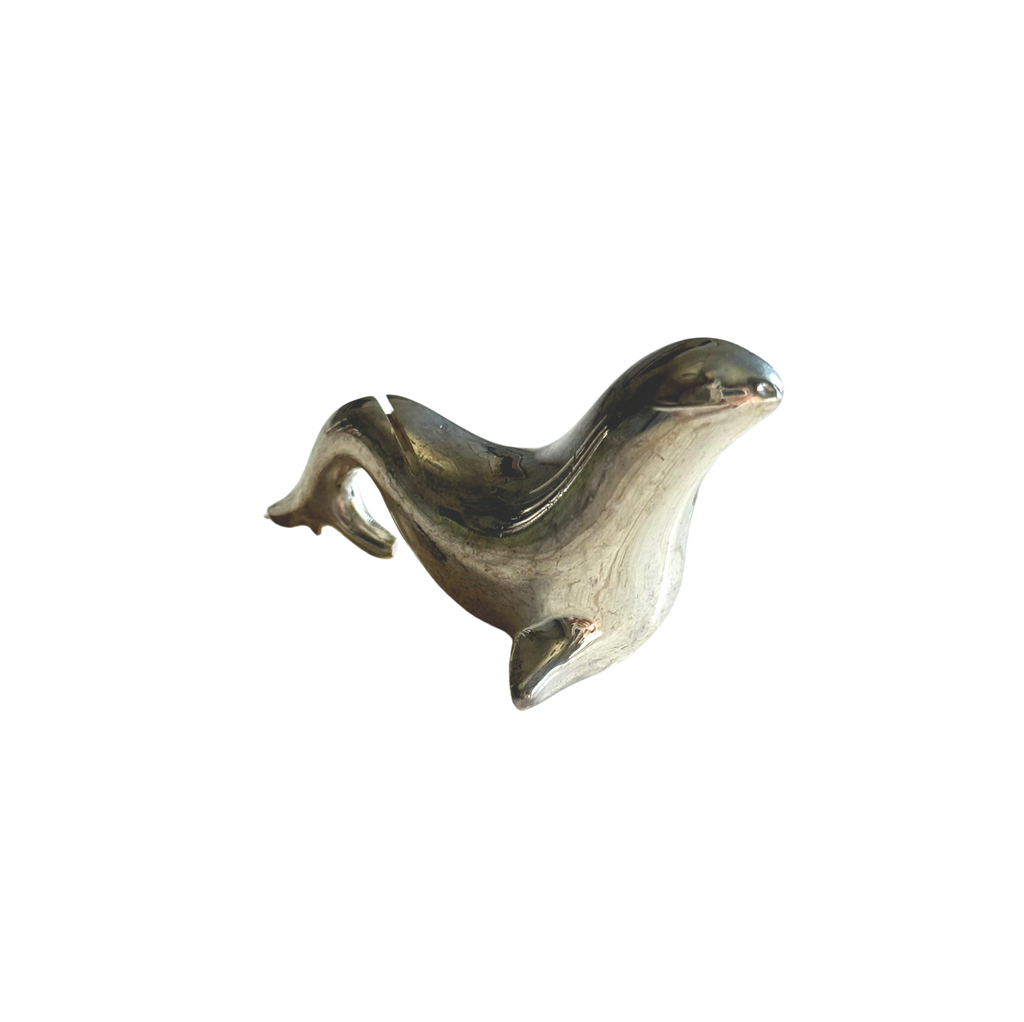 A polished metallic seal figurine or decorative object, shown on a plain white background.