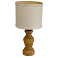 A table lamp with a natural wood turned base and a beige linen drum shade, isolated on a white background.