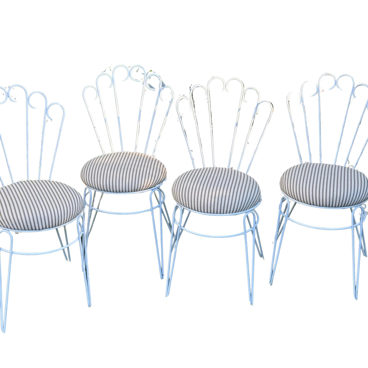 Four vintage-style metal dining chairs with light blue painted frames and striped gray cushions, shown against a plain white background.